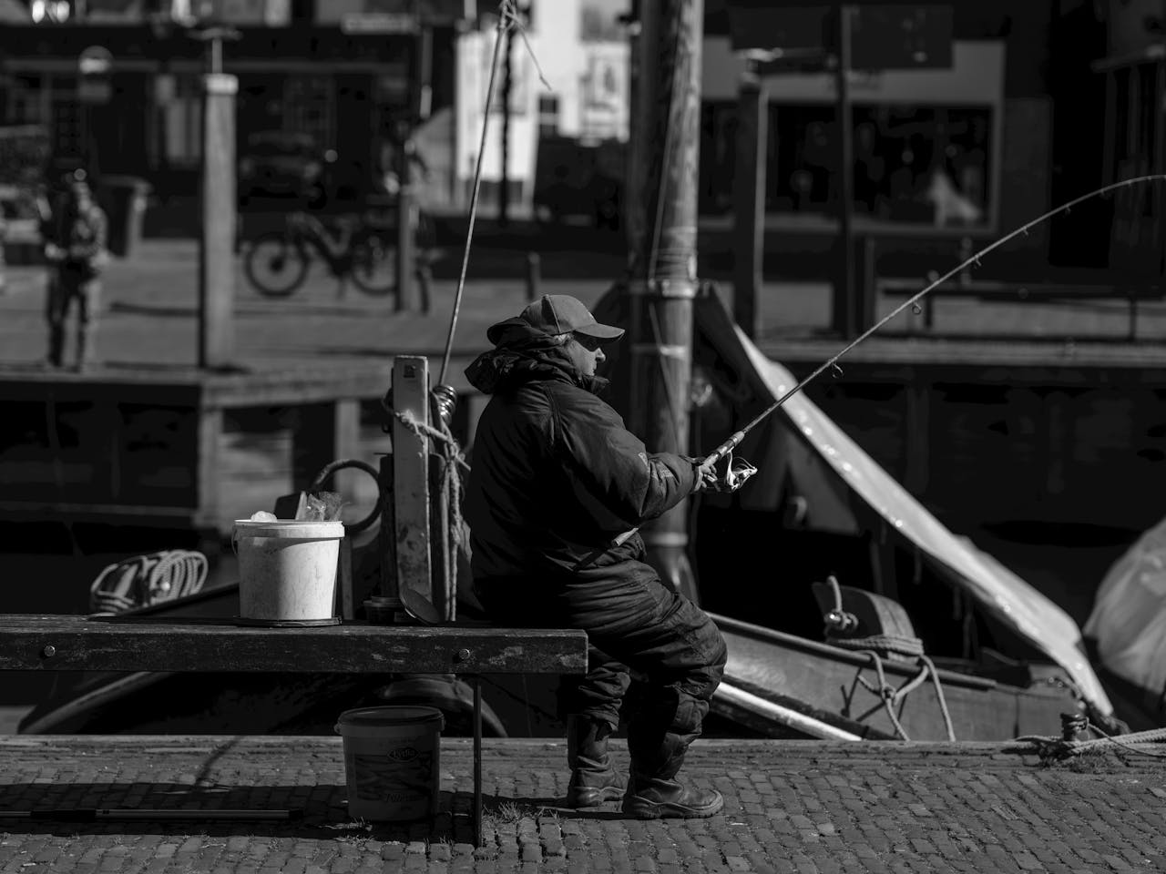 heros-img Black and white image of a fisherman on a quay in Bunschoten-Spakenburg, Netherlands.